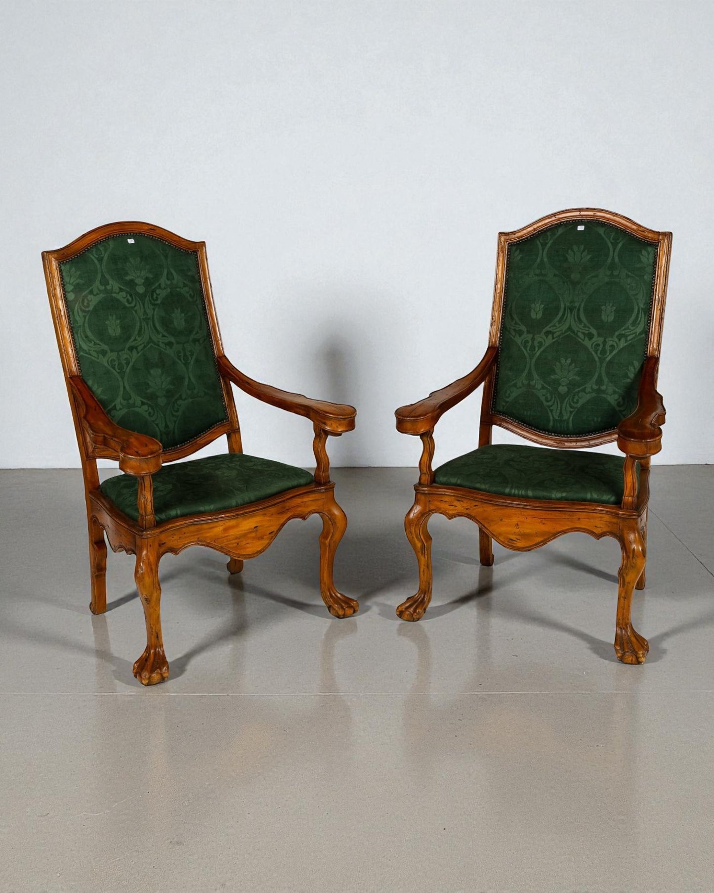 Pair of high back armchairs , scrolled arm brackets, claw feet resting on spheres 20C