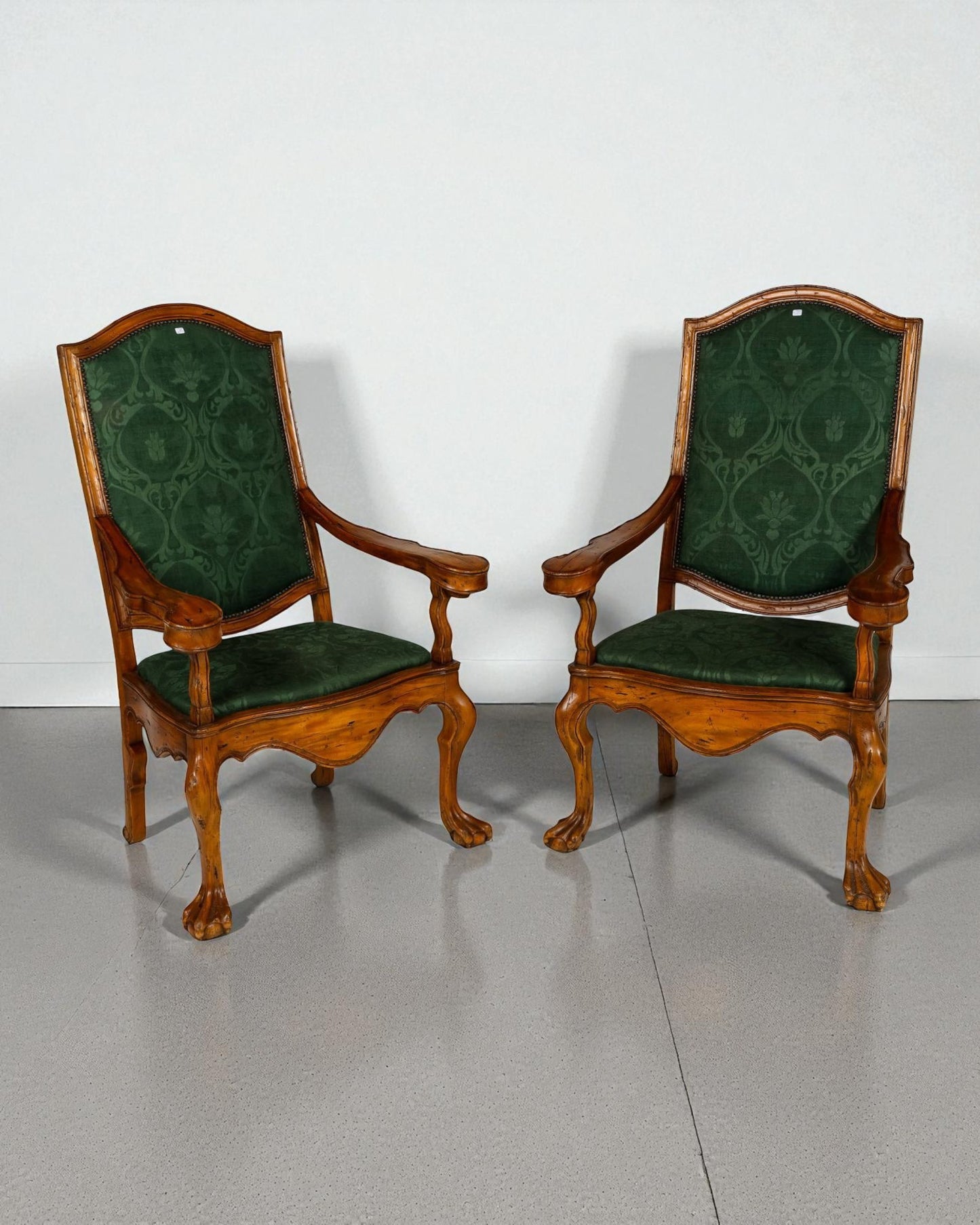 Pair of high back armchairs , scrolled arm brackets, claw feet resting on spheres 20C